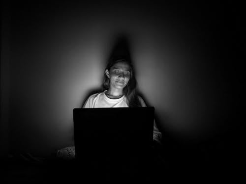 Black and White Photo of a Woman Using a Laptop