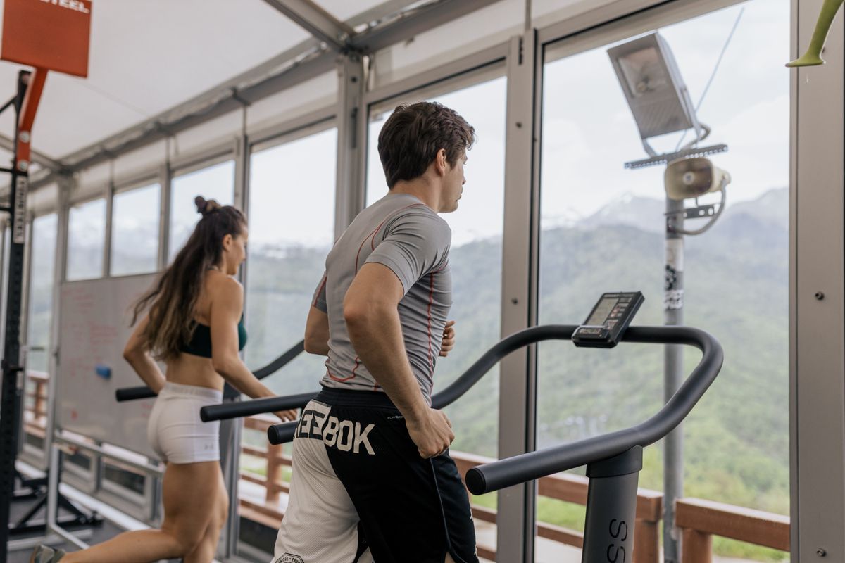 People exercising side by side on treadmills in a gym