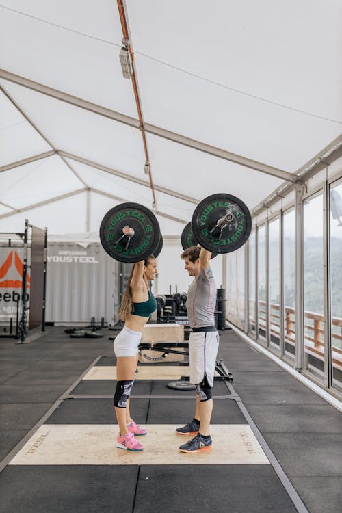 Man and Woman Lifting Barbells