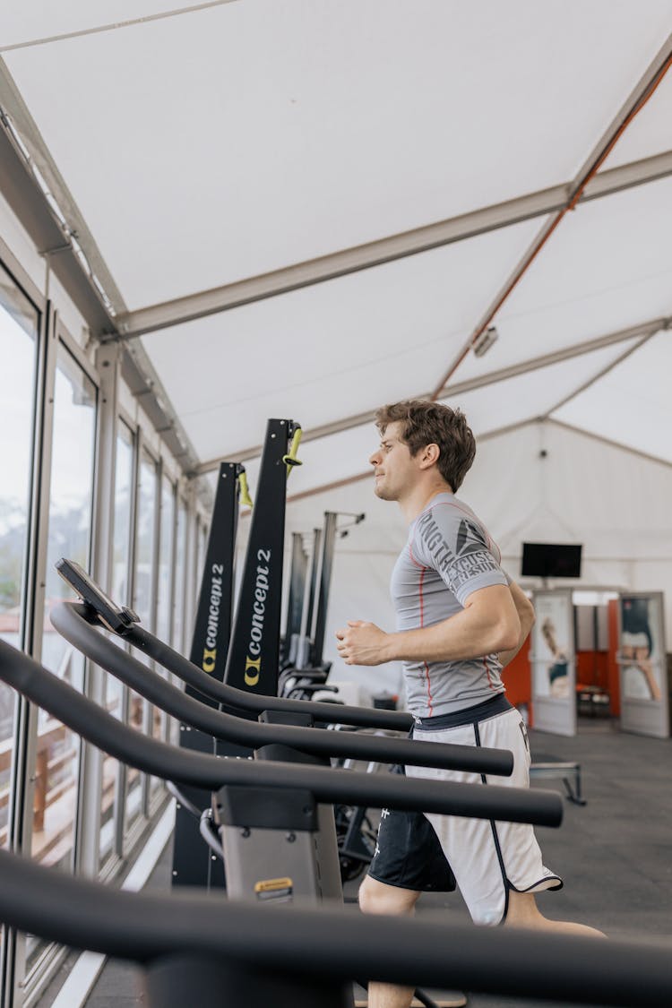 Man In Gray Shirt Running On A Treadmill