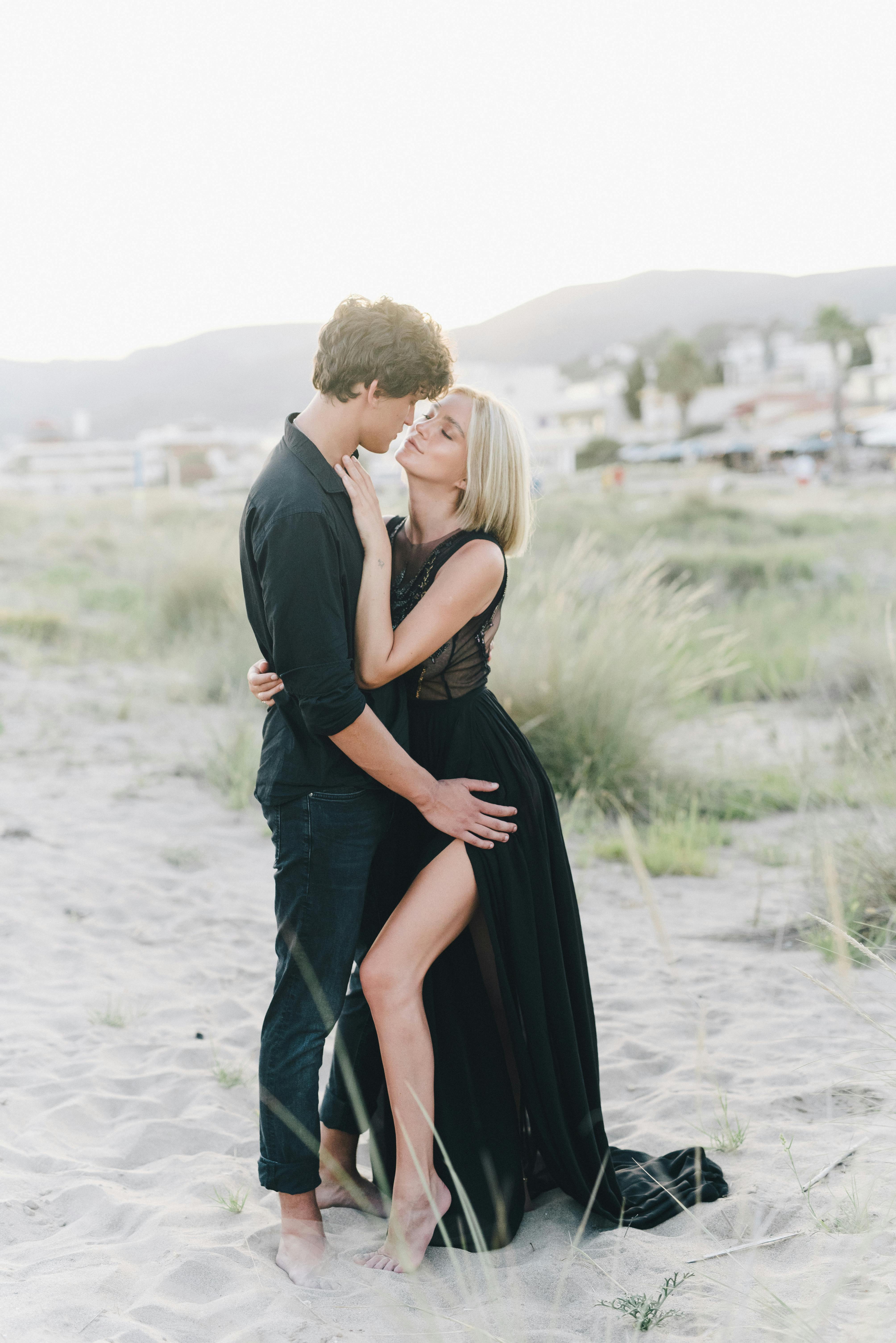 man and woman standing on white sand