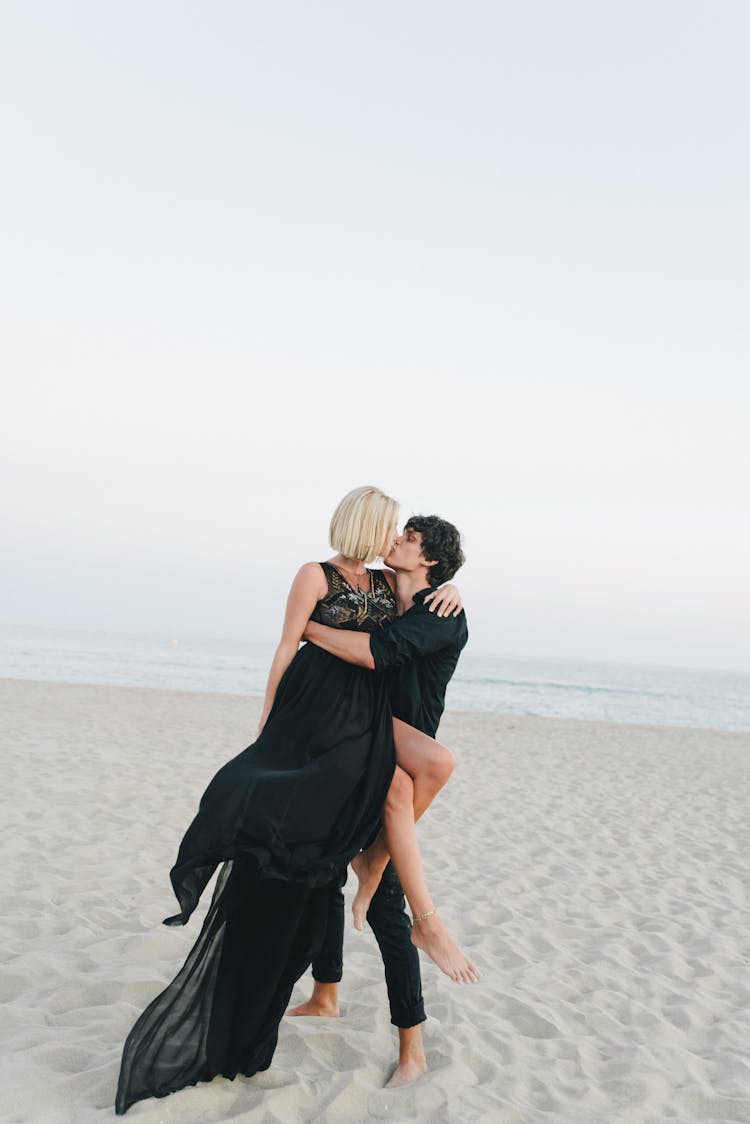 A Couple Kissing On The Beach 