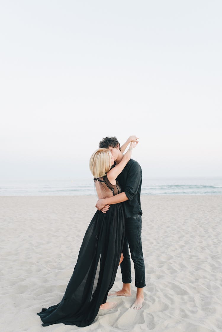 A Couple Kissing On The Beach