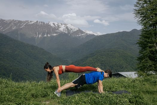 一对夫妇在风景如画的山地景观中进行户外锻炼，展现了健康的生活方式