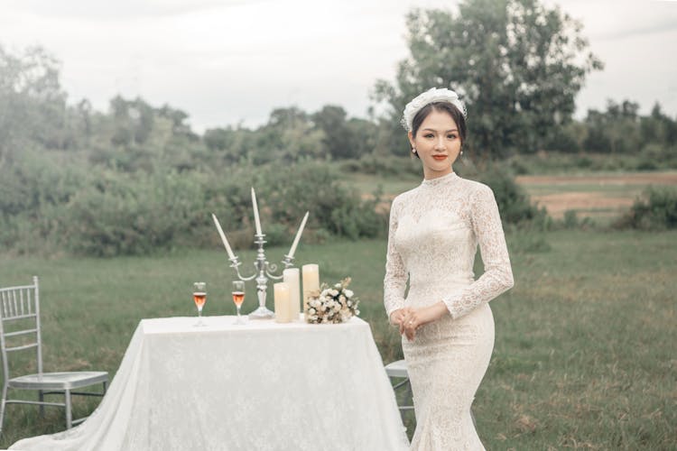 Bride Standing Next To Table At Outdoor Wedding