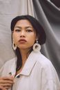 Stylish Asian woman in light room