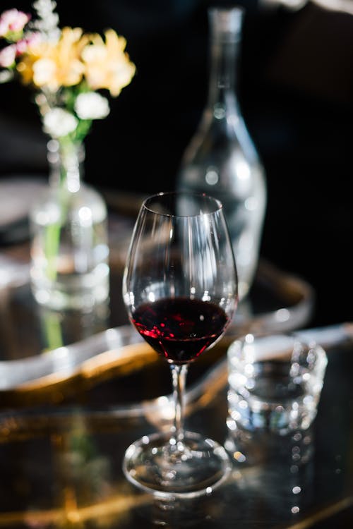 Glass of red wine on creative glass table