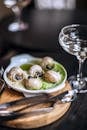 High angle delicious escargots appetizer served on wooden board in fine dining French restaurant