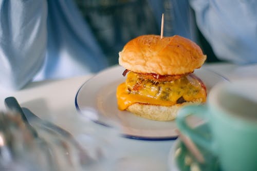 Crop person at table with hamburger