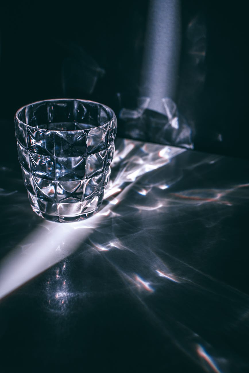 Glass with refraction pattern in darkness · Free Stock Photo