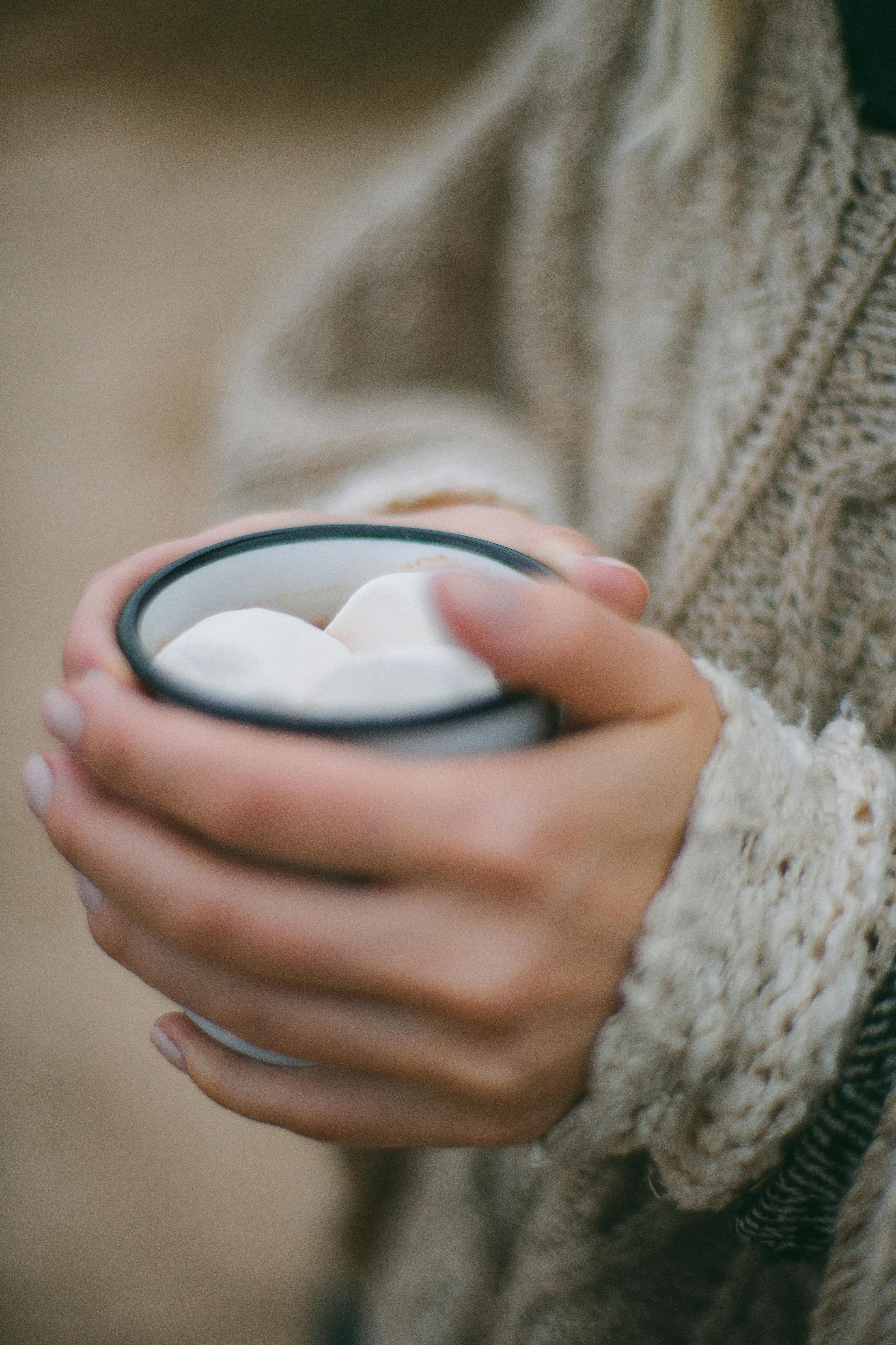 woman with cup of hot drink with tasty sweet marshmallow