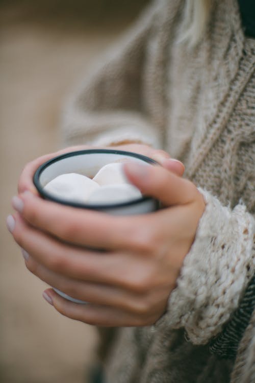 Woman with cup of hot drink with tasty sweet marshmallow