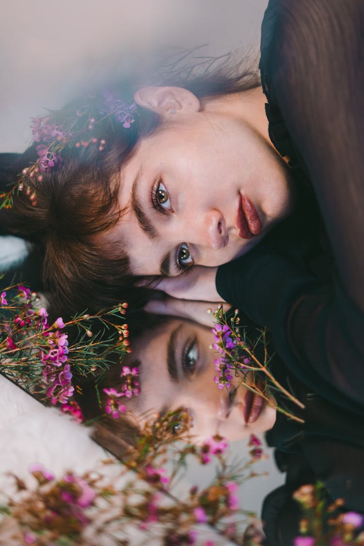 Young Content Woman Among Gentle Purple Flowers