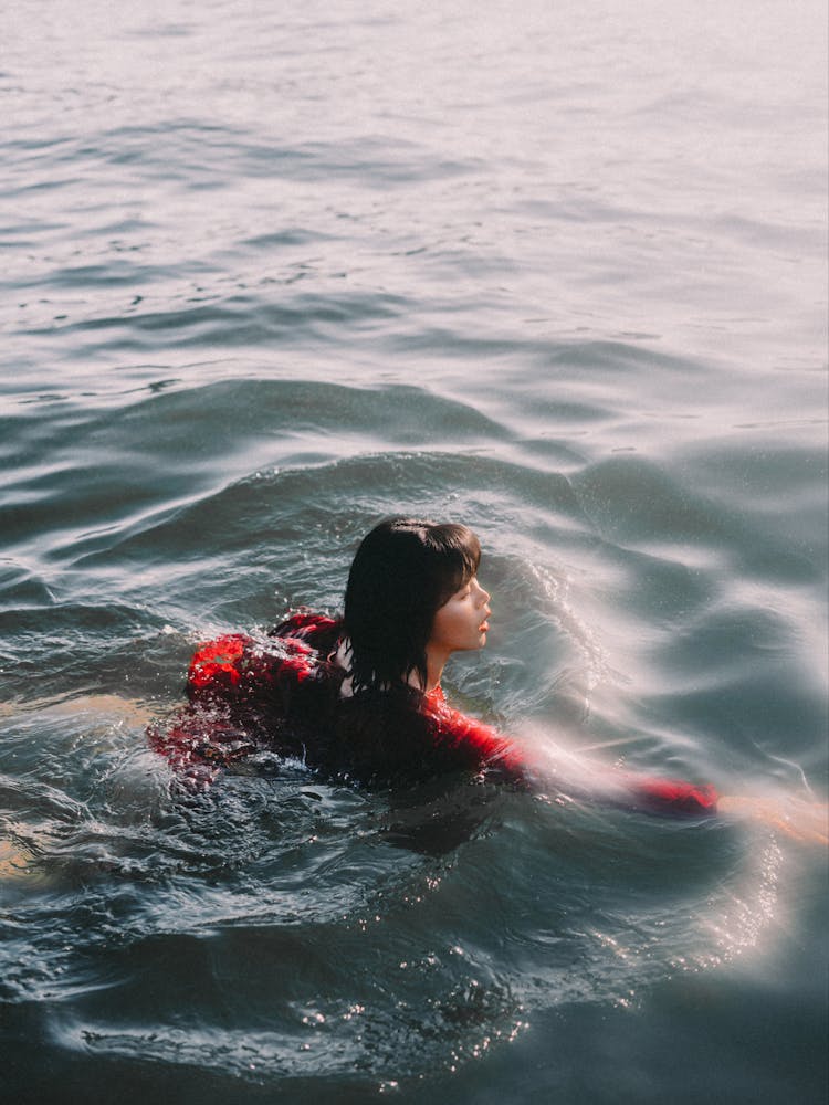 Asian Woman Swimming In Calm Water Of River