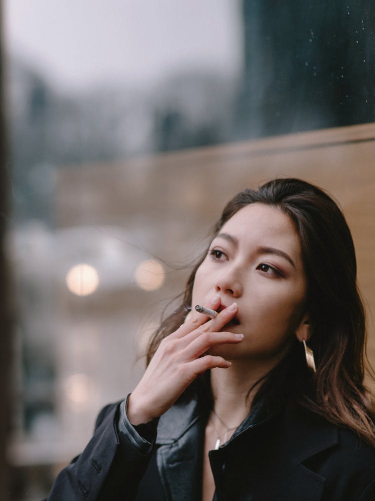 Thoughtful Young Woman Smoking Cigarette