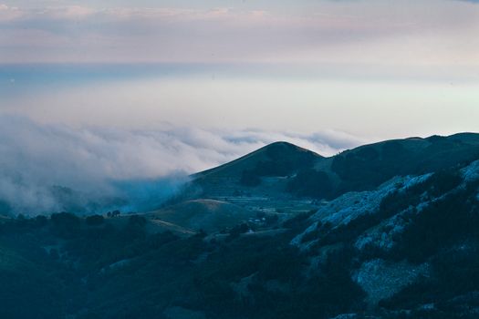 傍晚时分，高山绿树成荫，云雾缭绕，风景如画