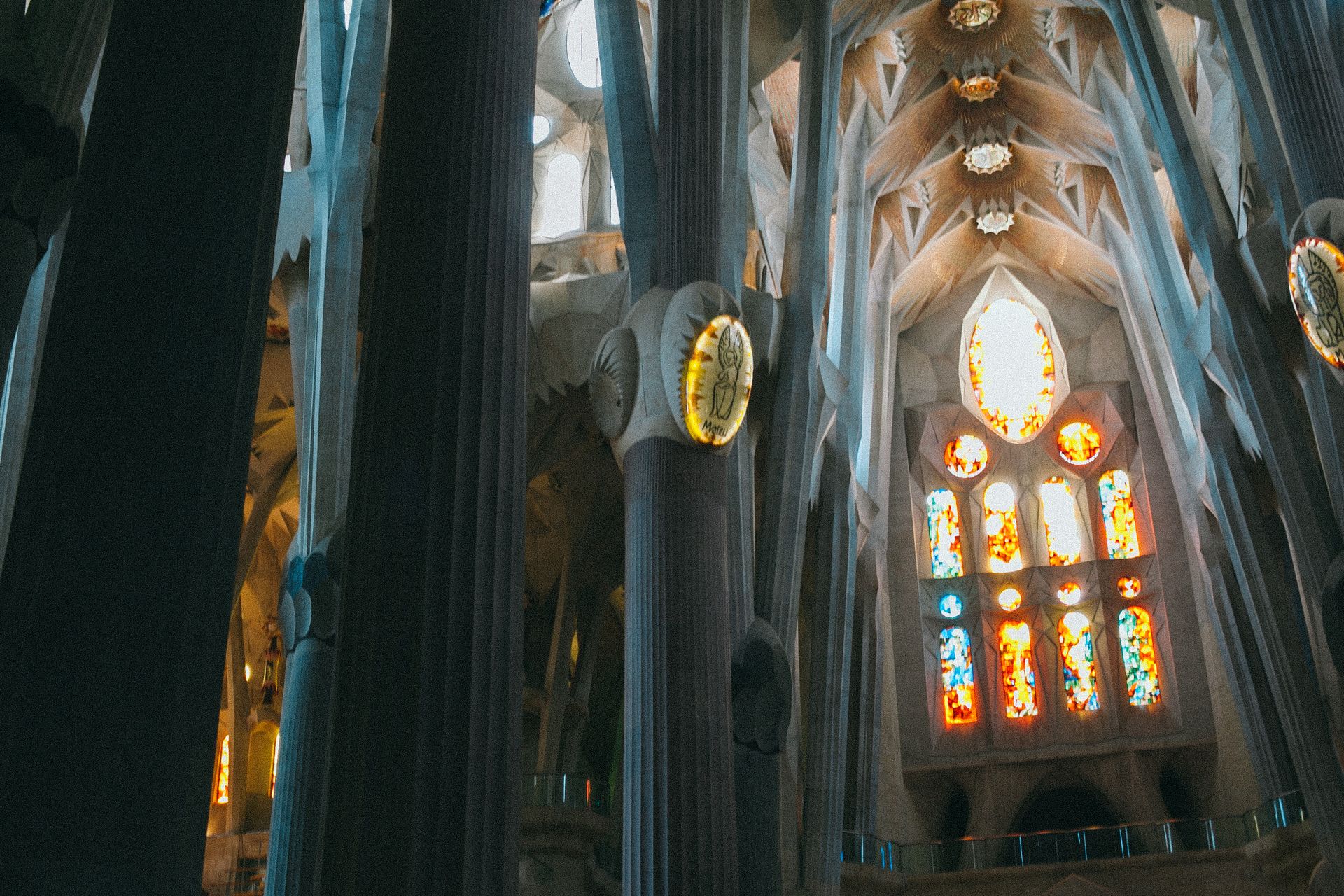 From below of tall columns and ceiling in Gothic style in Catholic landmark of Spain Sagrada Familia