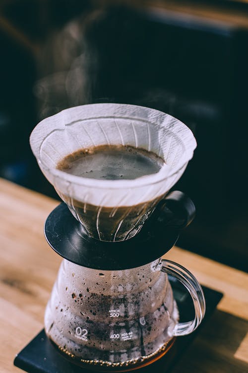 Coffee pouring into glass pot in cafe