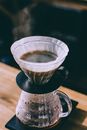 Coffee pouring into glass pot in cafe