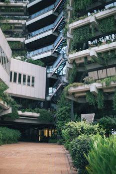 当代建筑在垂直结构上以绿色植物为特色，融入城市环境