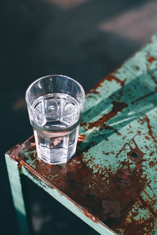 Free High angle of glass with fresh cold water placed on shabby surface in light room Stock Photo