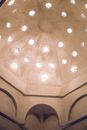 From below of arched ornamental ceiling decorated with carved stars in stone building of hammam