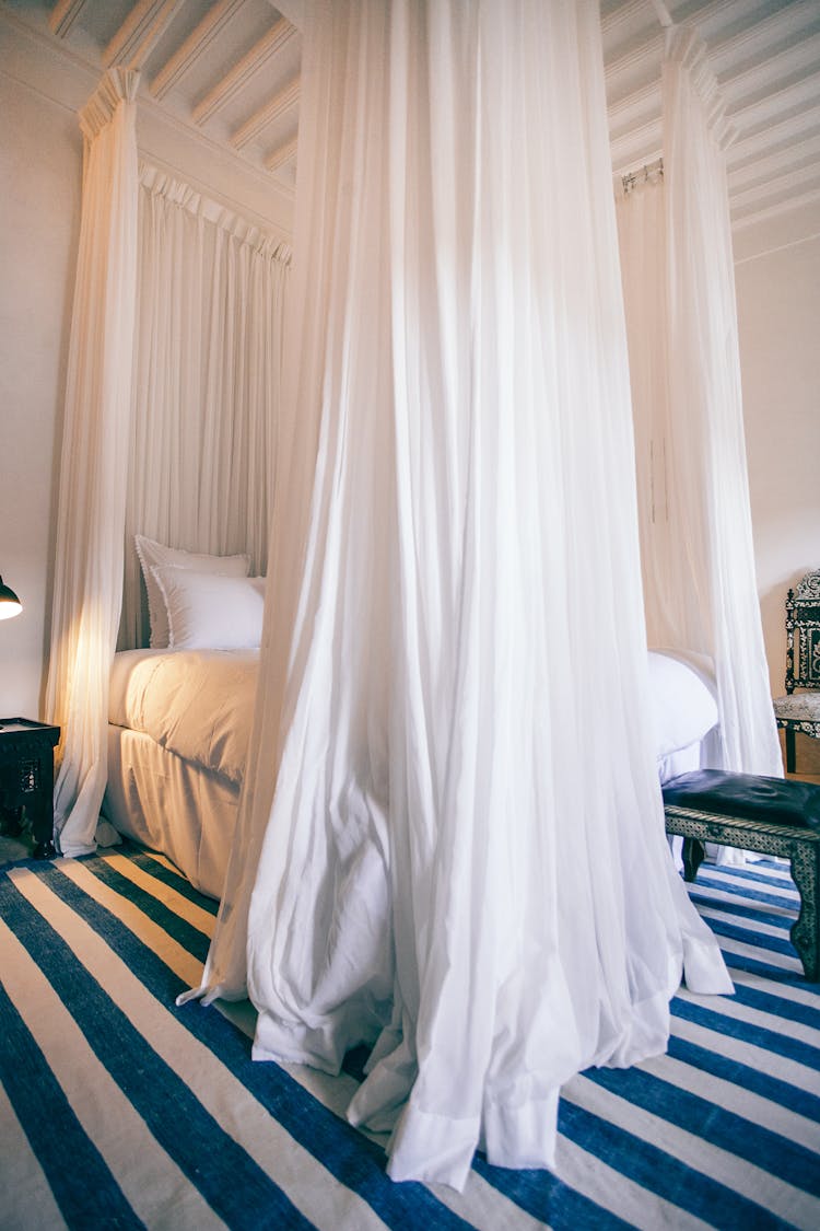 Bed With Curtains In Hotel Room