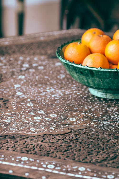 From above of fresh appetizing ripe citrus fruits of oranges in bowl on carved table