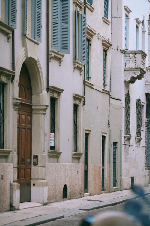 Free Facade of small residential building with arched doorway on narrow paved street in town Stock Photo