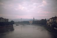 Picturesque view of calm wide river flowing by embankment in city in overcast weather
