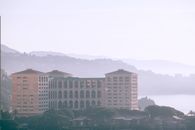 一座现代建筑，以朦胧的天空和宁静的山间为背景