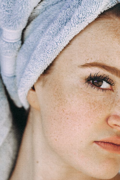 Free Young woman with brown eyes and freckled face and with towel turban on head looking at camera Stock Photo