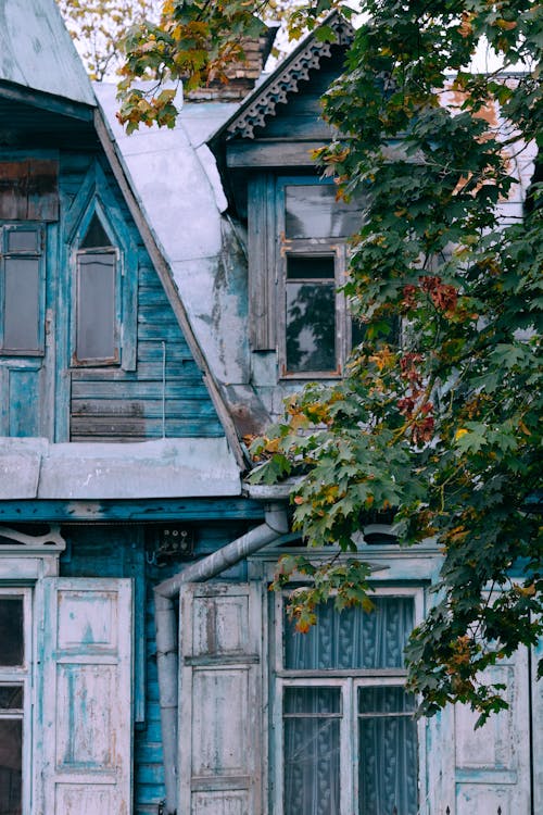 Exterior of aged weathered residential building with wooden shutters on windows in poor village