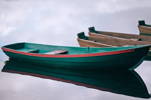 青空の下で水に赤と緑のボート
