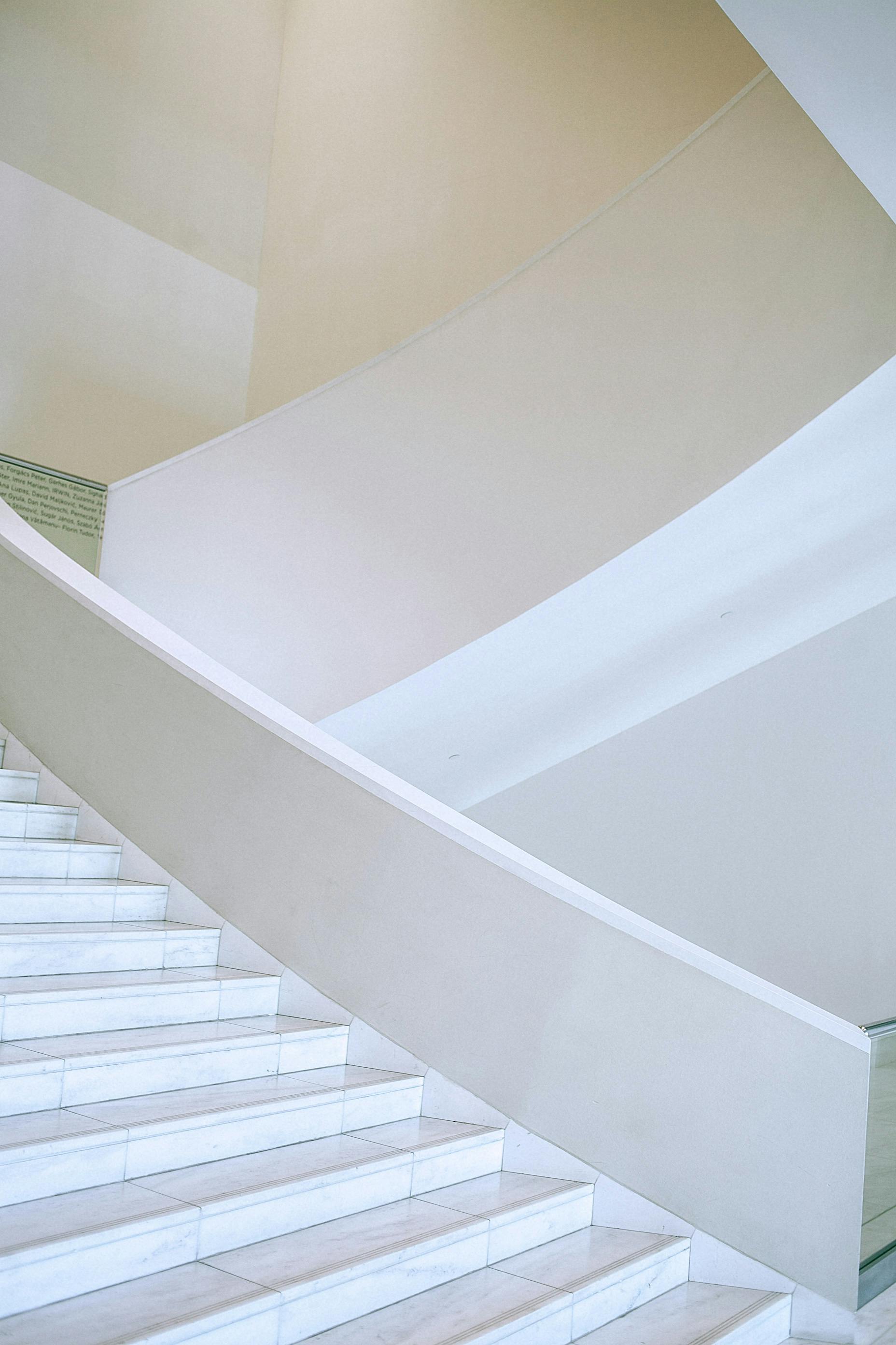 white staircase flight in spacious light hallway