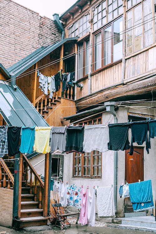 Free Laundry drying on clothesline outside shabby poor house Stock Photo