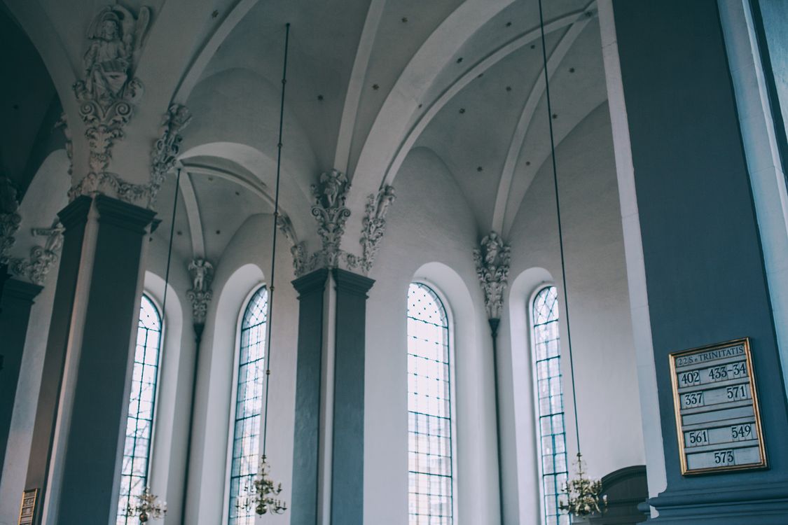 Free From below of aged baroque catholic cathedral interior with blue columns and ornamental details on arched ceiling in daytime Stock Photo