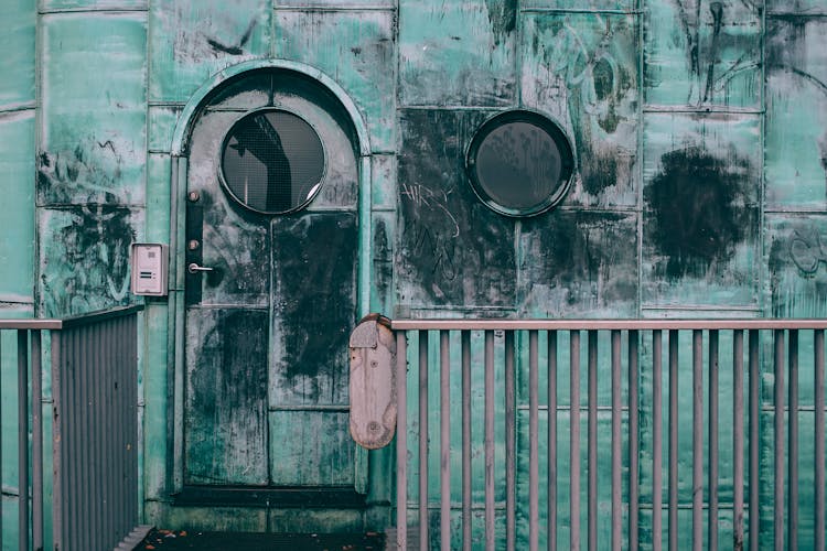 Old Shabby Cabin With Combination Lock And Round Windows