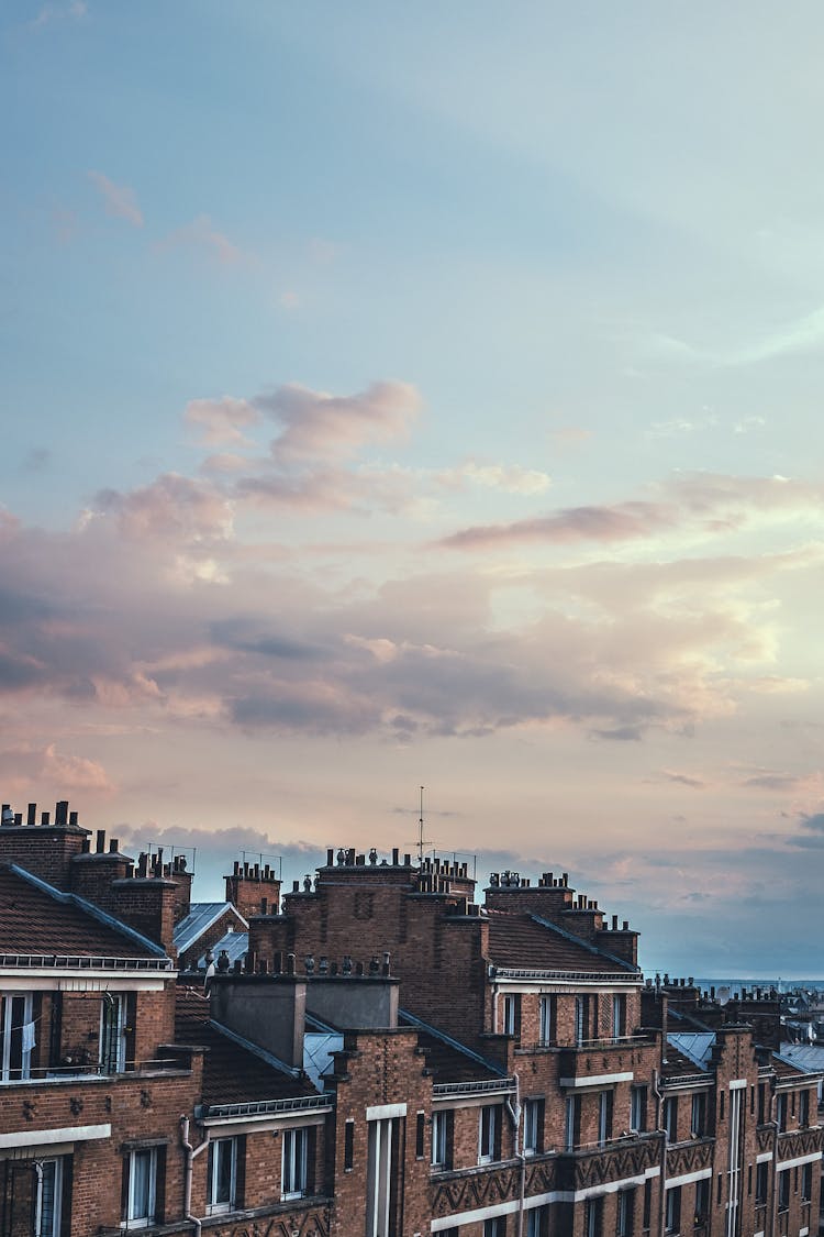 Picturesque Cityscape With Brick Residential House Under Partly Cloudy Sky