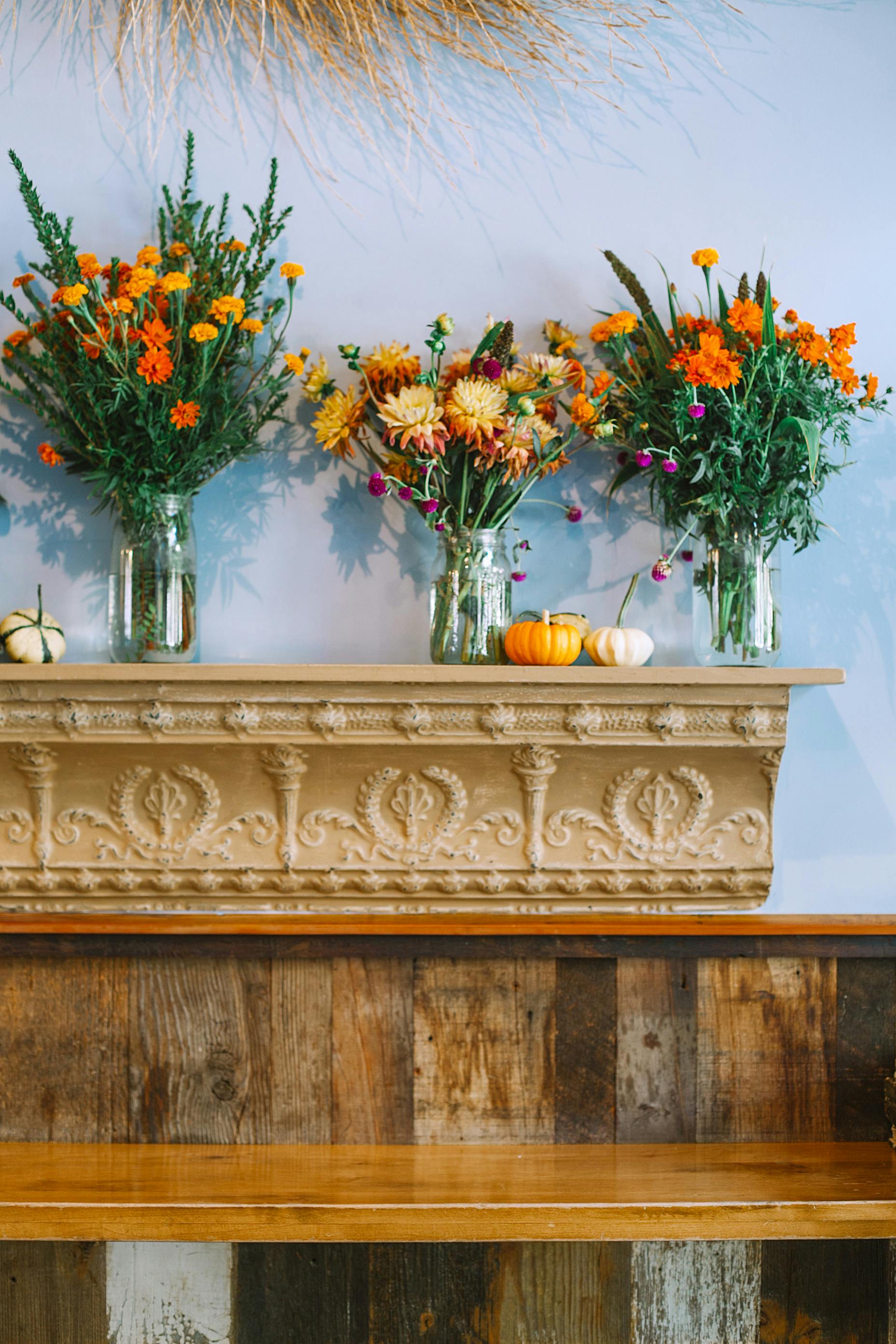 华丽的架子上，装饰着浮雕的玻璃花瓶里插着五颜六色的花朵