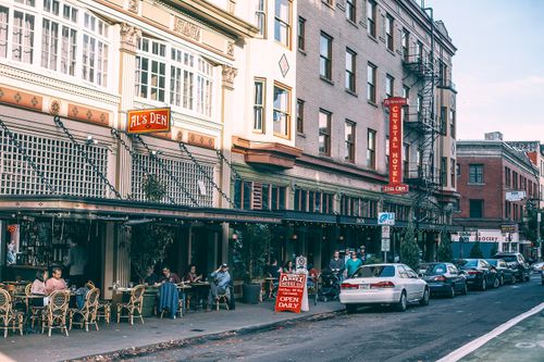 Free Exterior of residential building with cafe and cars parked on narrow asphalt road in city Stock Photo