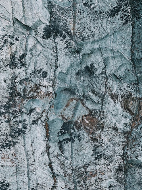 From above of rough rocky surface of rock formation with cracks and veins in daylight