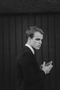 Businessman in suit near wall in daytime