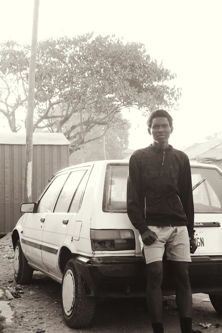 Pensive Black Man Near Old Car