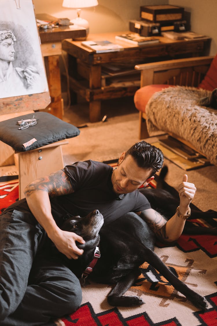 Satisfied Man With Dog On Carpet In Modern Room