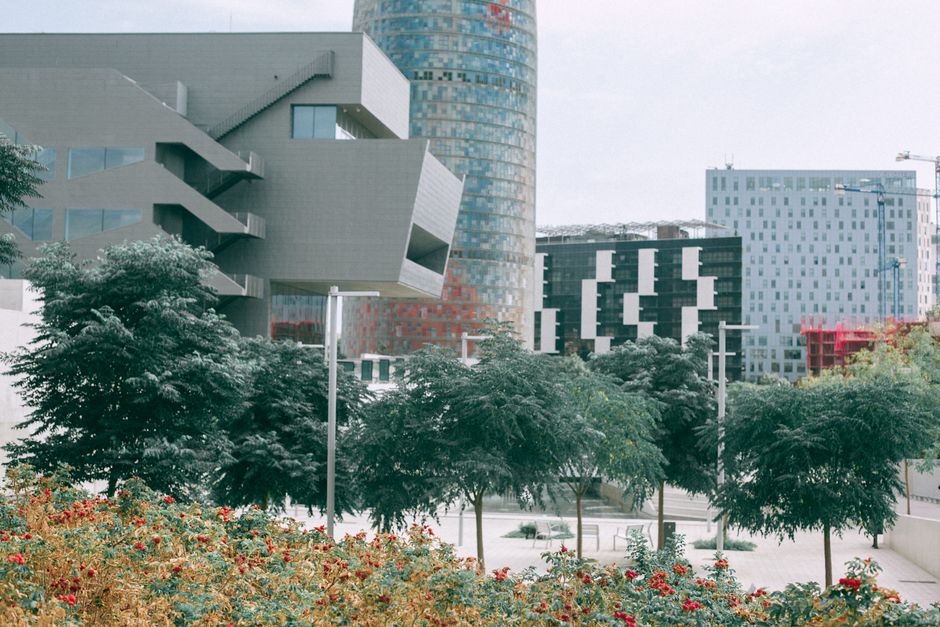Edificios urbanos futuristas rodeados de vegetación exuberante y diseños geométricos a plena luz del día.