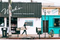 Man with surfboard walking along street