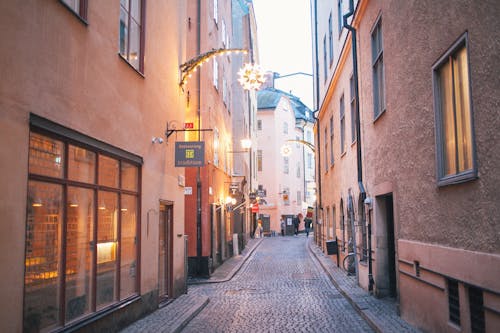 Narrow pedestrian street between old residential buildings at twilight