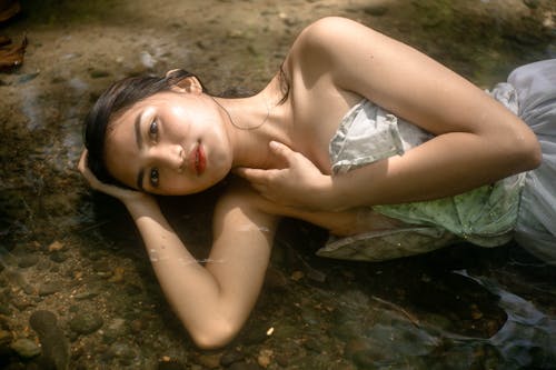 Relaxed woman in dress lying in water