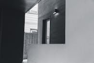 Wall mounted lamp near door in yard of modern house